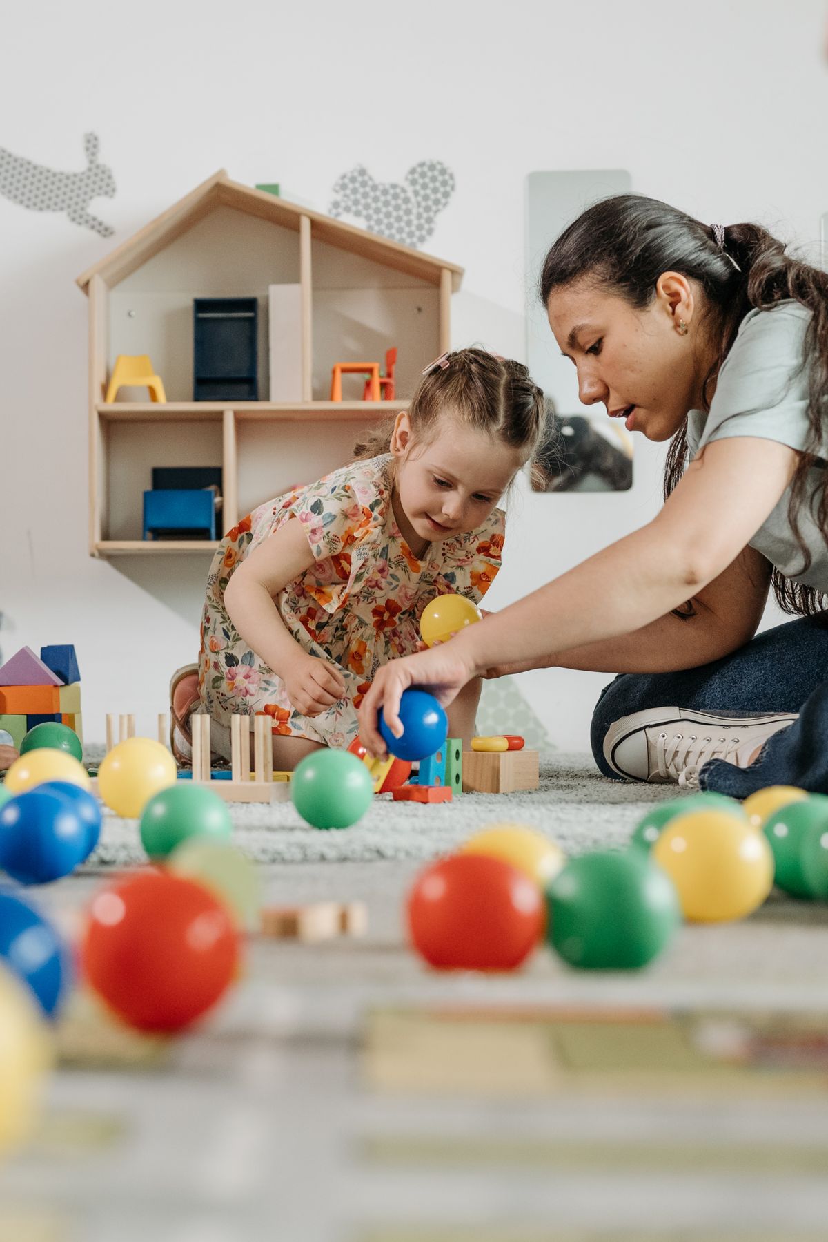 A therapist sitting on the floor engaging a young child during a play-based session